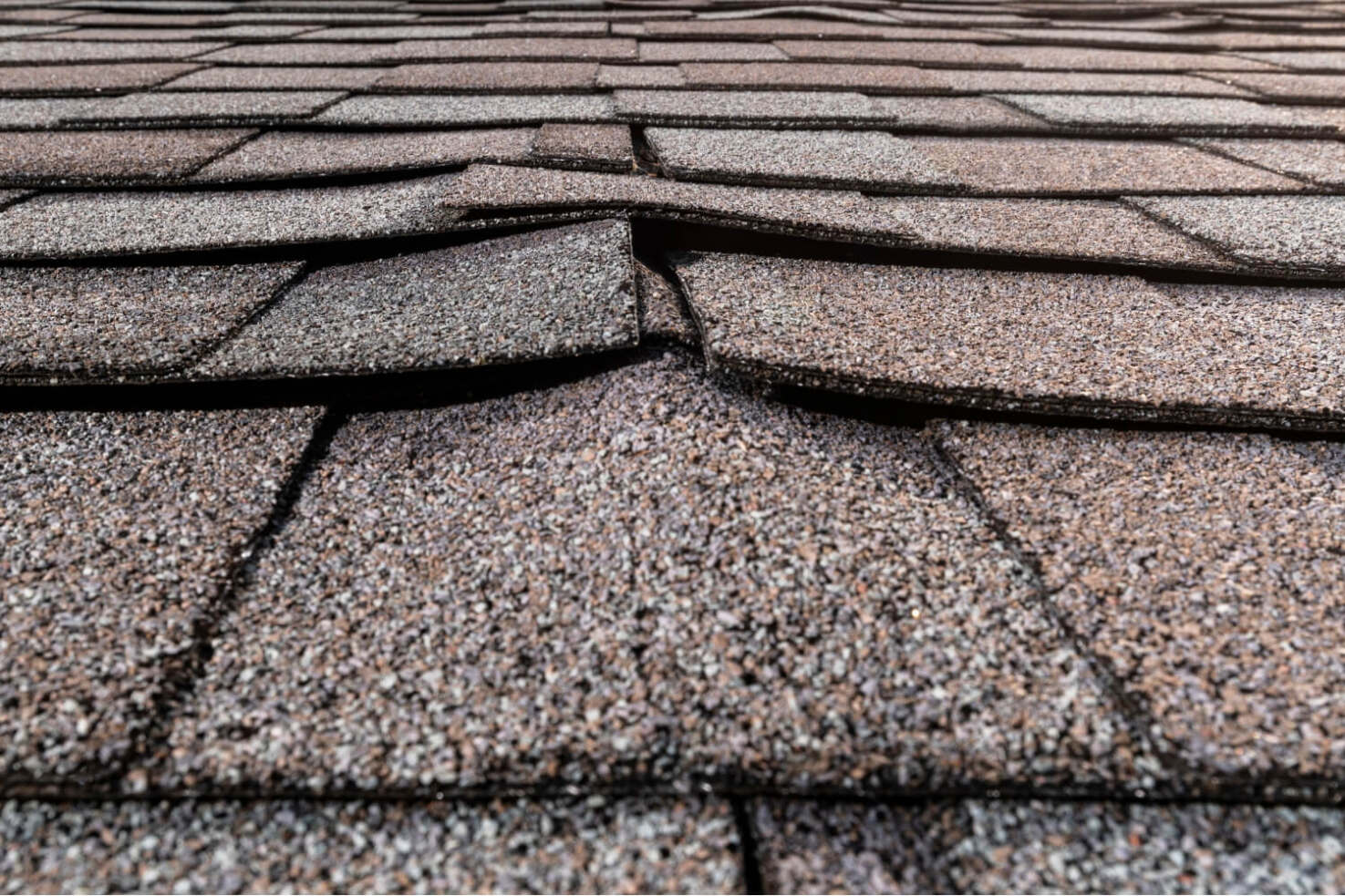 A photo showing various types of buckled shingles on a roof