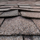 A photo showing various types of buckled shingles on a roof