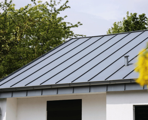 Black metal roof on white home 1