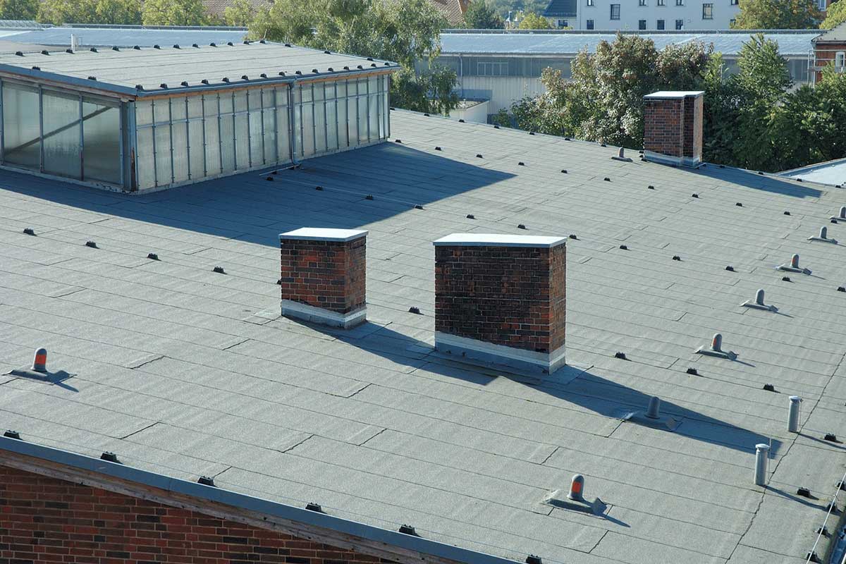 Illustration of a roof with a cricket diverting water away from a chimney