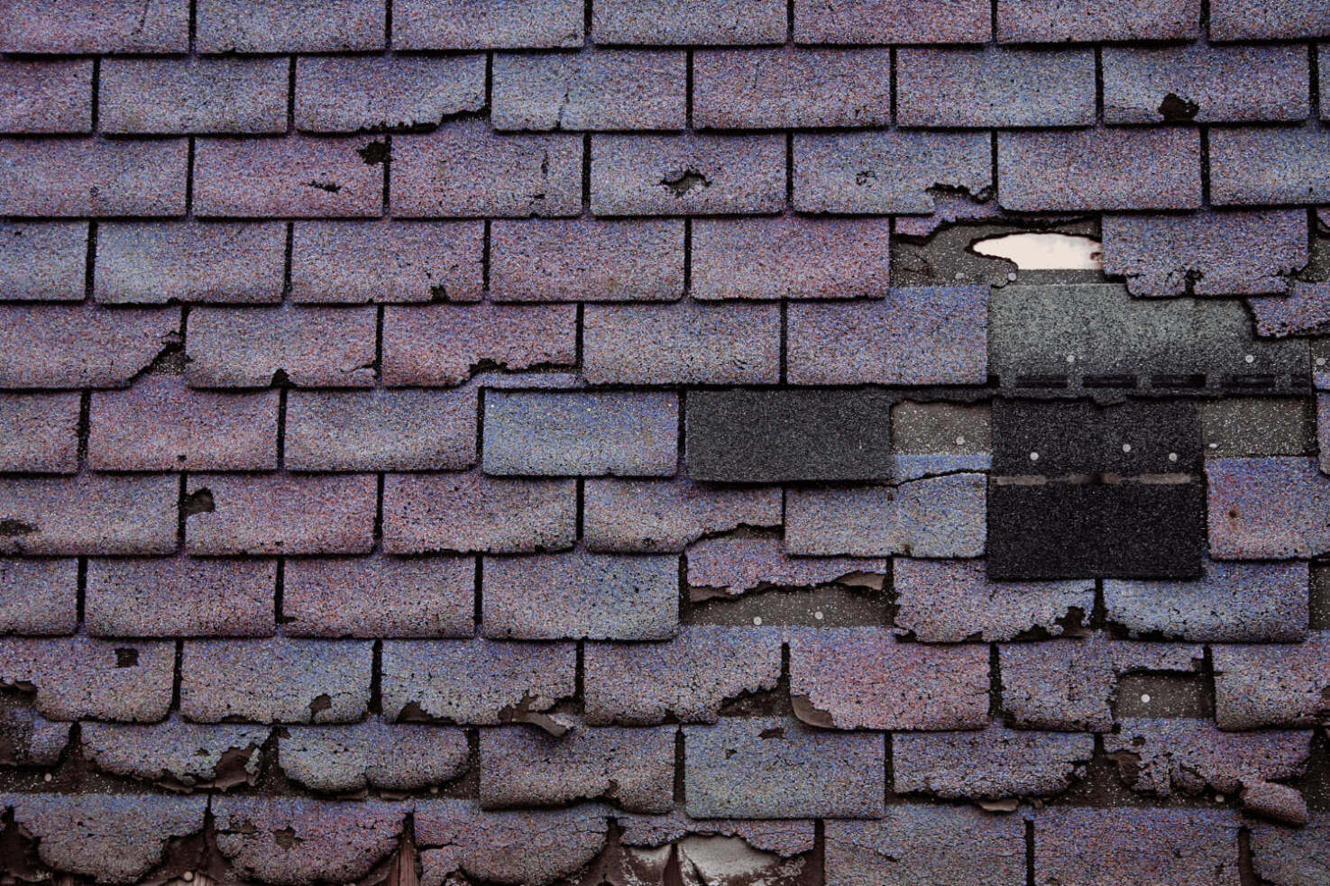 A roof showing signs of wear and old shingles indicating the need for replacement