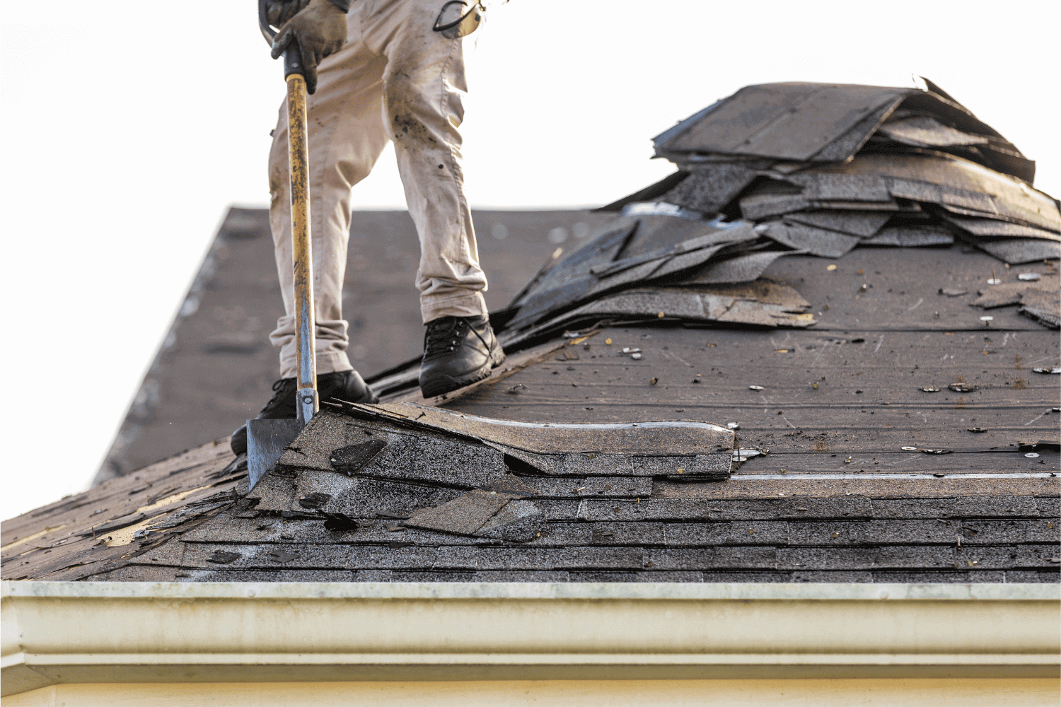 Essential tools for the shingle removal process including a roofing shovel and safety gear