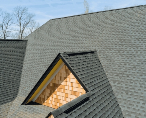 Ridge cap shingles being installed on a roof.