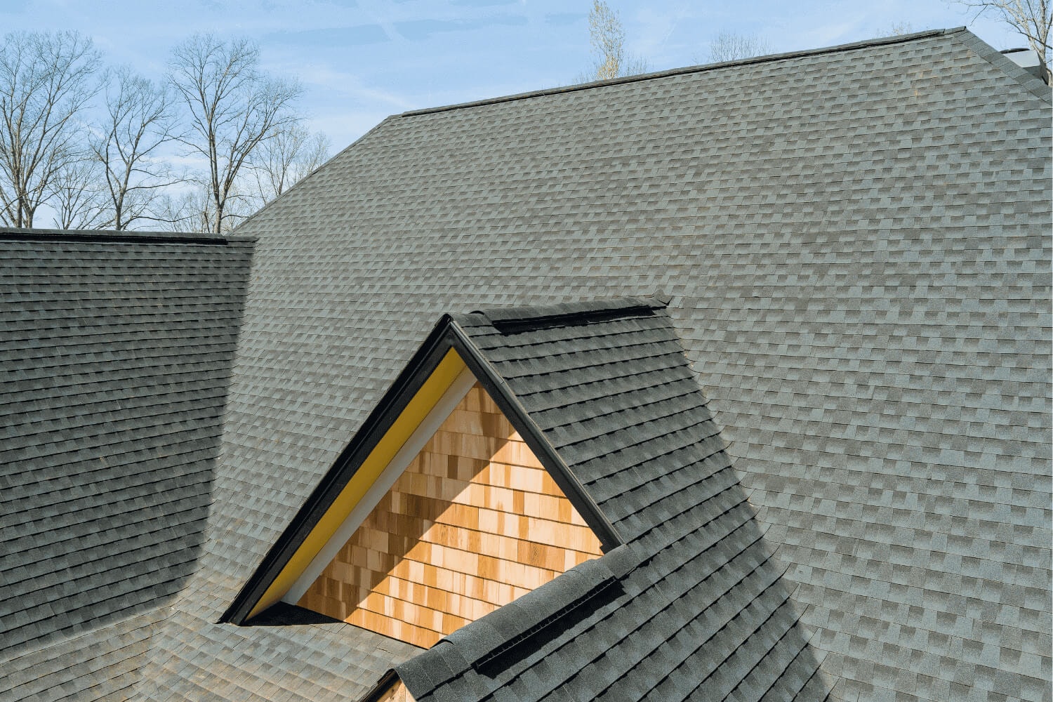 Ridge cap shingles being installed on a roof.