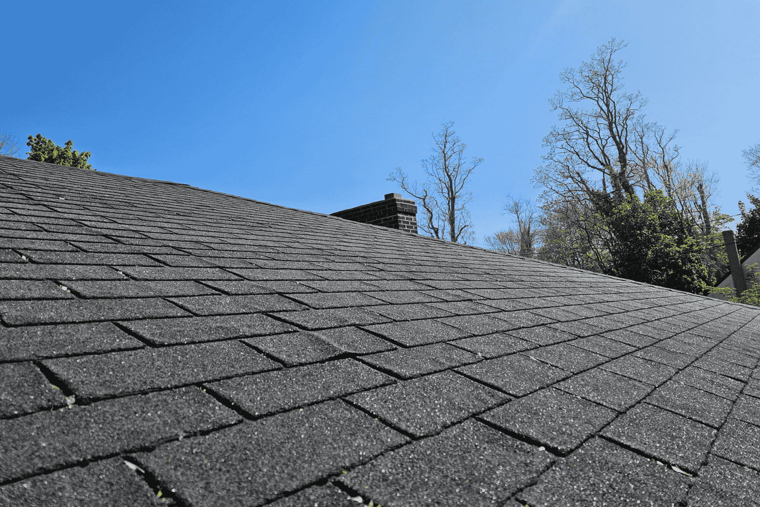 A comparison of asphalt shingles vs architectural shingles, showcasing their different styles.