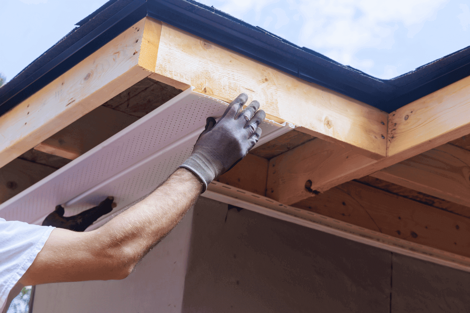 Installing soffit and fascia alongside vinyl siding.