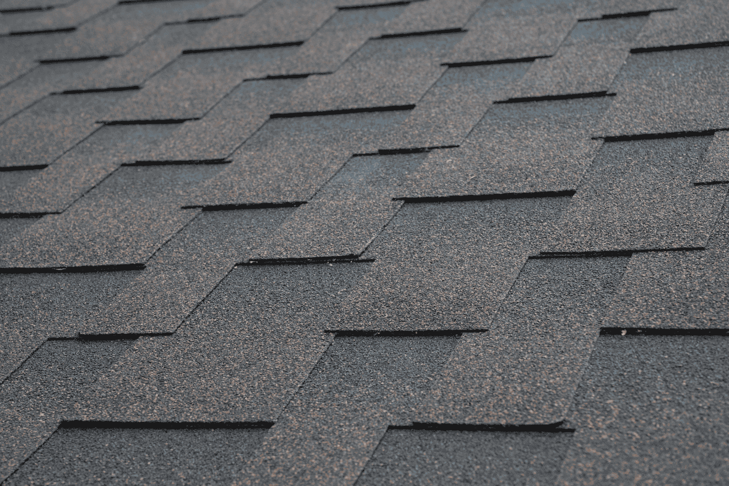 A close-up view of architectural shingles, illustrating their layered structure.