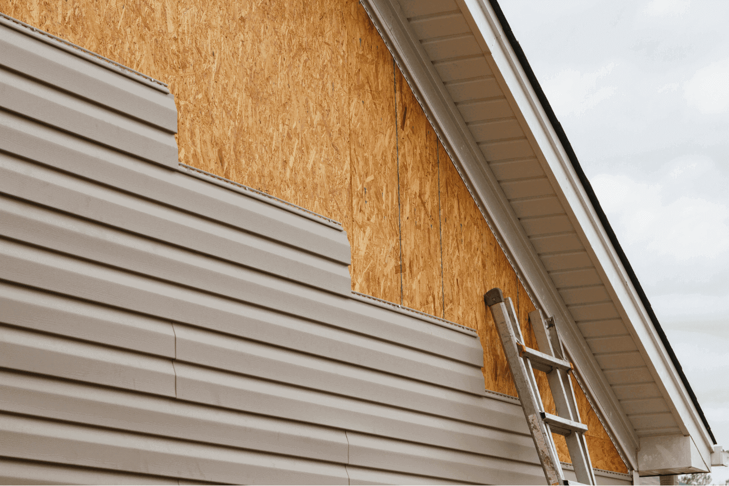 The process of installing vinyl siding panels on a house.