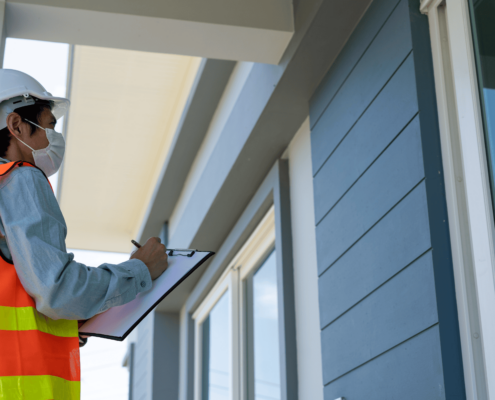 A person inspecting a roof for leaks, looking for signs of roof damage.