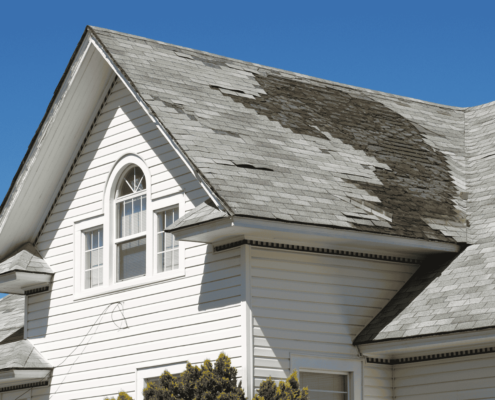 A person inspecting a roof for signs of damage, including roof repair work.