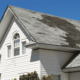 A person inspecting a roof for signs of damage, including roof repair work.