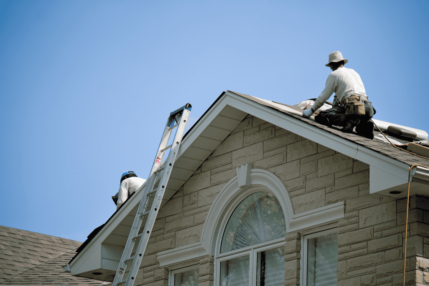 A worker performing roof repairs to prevent water damage.