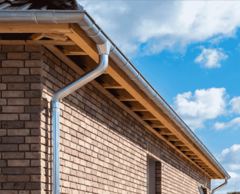 An image showing the installation process of a downspout cleanout.